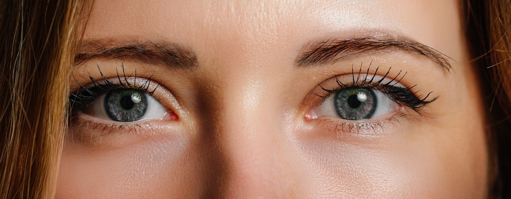 Close-up of woman’s eyes with green irises and natural makeup, illustrating results or treatment area for under-eye fillers to reduce dark circles and hollowness.